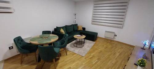 sala de estar con sofá, mesa y sillas en Zeleni Raj, en Zlatibor