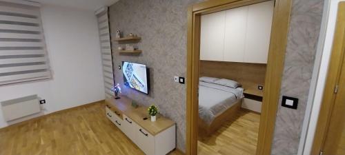 1 dormitorio con cama y espejo en Zeleni Raj, en Zlatibor