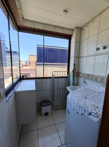 a bathroom with a tub and a sink and a window at Apto 2 dorm com vista para o mar in Capão da Canoa