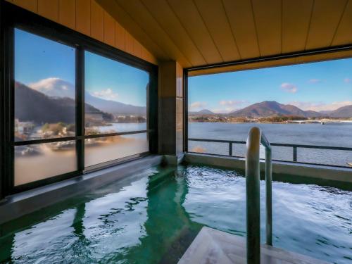 a swimming pool with windows and a view of the water at Hotel Asafuji in Fujikawaguchiko