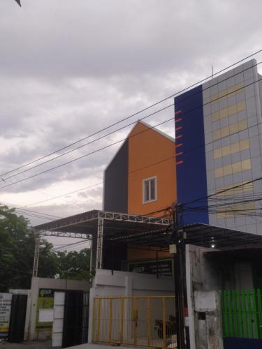 a building with a colorful facade on top of it at Autumn Living Hostel in Surabaya