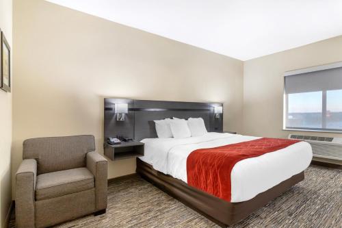 ein Hotelzimmer mit einem Bett und einem Stuhl in der Unterkunft Comfort Inn in Orange