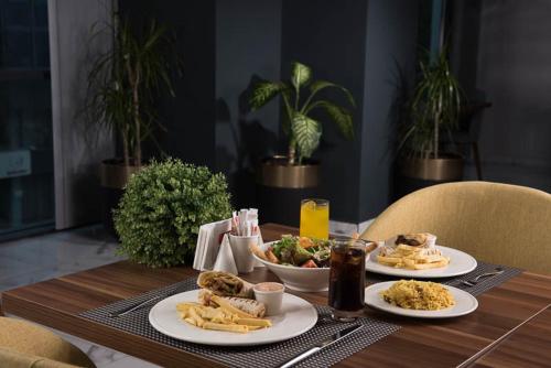 a wooden table with plates of food on it at İbos Hotels Izmir in Izmir