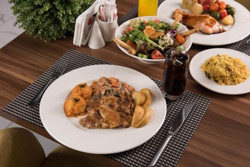 a wooden table with plates of food on it at İbos Hotels Izmir in Izmir