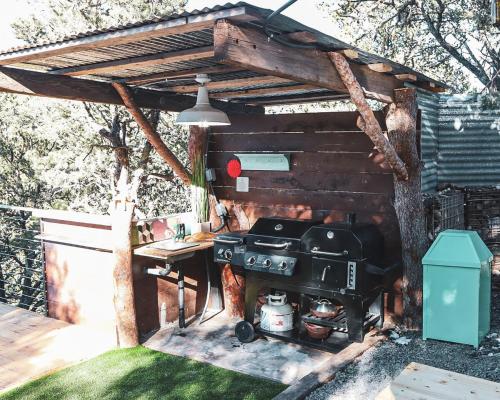an outdoor kitchen with a grill and a table at Zia Geo Dome At El Mistico Ranch, Glamping in Nogal