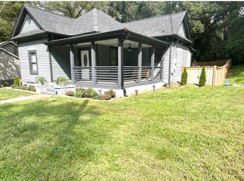 a small house with a porch on a yard at Stylish, Fully Furnished Home in Dwtn Atlanta in Atlanta