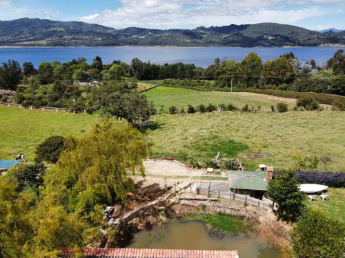 an aerial view of a field with a lake at Cabaña Isla Dorada in Guatavita