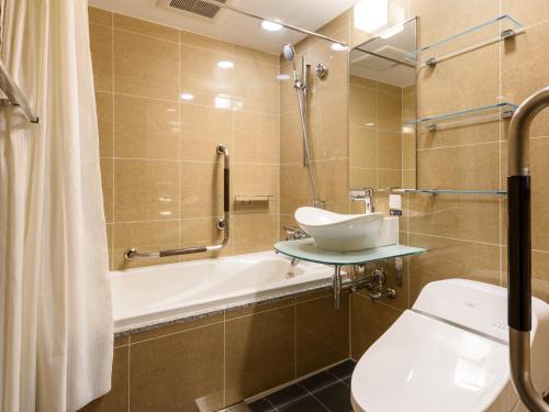 東京にあるアパホテル〈八丁堀 新富町〉の洗面台、浴槽、トイレを備えたバスルーム