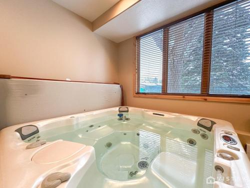 a large bath tub in a room with two windows at Silver Star Ski Retreat W Private Hot Tub! in Park City