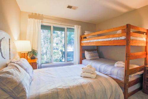 ein Schlafzimmer mit zwei Etagenbetten und einem Fenster in der Unterkunft Spriggs Shack in Kiawah Island