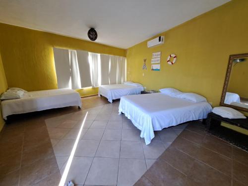 a bedroom with two beds and a yellow wall at Casa Privada San Blas in San Blas