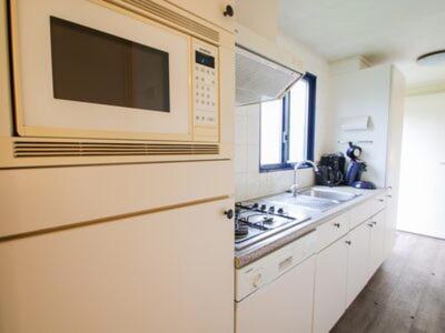 a kitchen with a sink and a microwave at Chalet Veluwe G10 Veldkamp 4 Personen in Epe