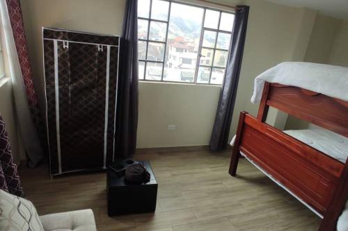 Habitación con dormitorio con cama y ventana en 4 Cuarto independiente con sala en Ambato, en Ambato