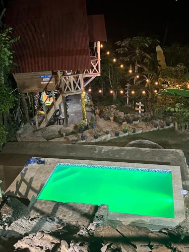- une piscine verdoyante dans le jardin la nuit dans l'établissement Ecovillalova, à Camú