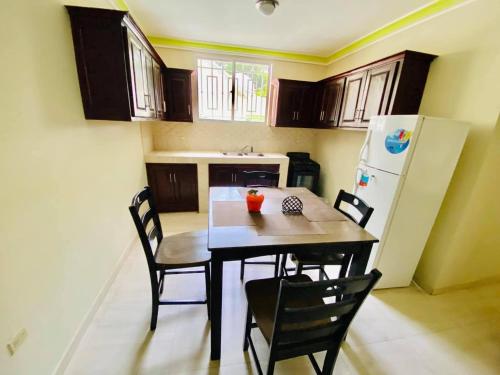 a kitchen with a table and chairs and a refrigerator at Le Bigot Appartements in Gonaïves