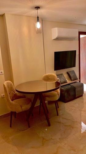 a living room with a table and two chairs and a tv at Sun gate house in Cairo