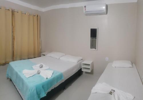 a hospital room with two beds and a window at Estrela Antônia - Praia de Santo Antônio in Matta de São João