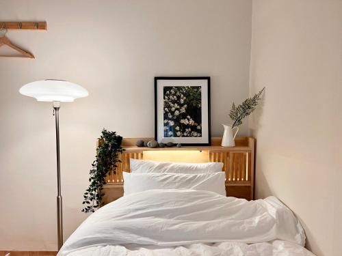 a bedroom with a bed with white sheets and a lamp at [New!] 3BR & 2Bath for big group in Seoul