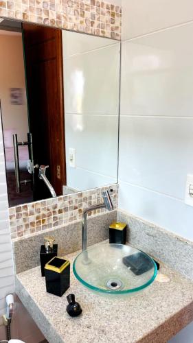 a bathroom counter with a sink and a mirror at Pousada OPA - O Paraíso é Aqui Abrolhos in Caravellas