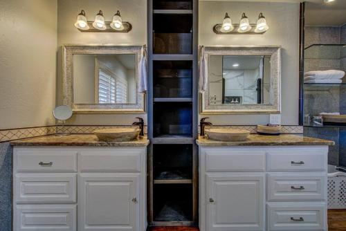 two sinks in a bathroom with two mirrors at Entire Cozy Getaway with Pool in Norman