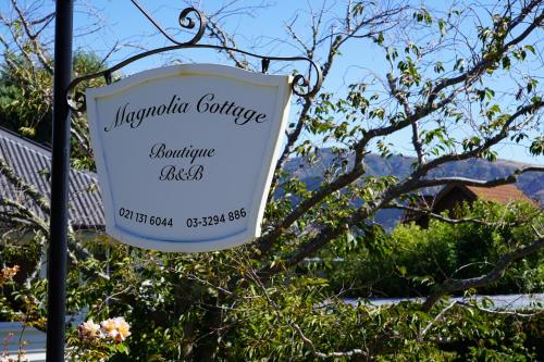 a sign for a margaritaville garden at Magnolia Cottage in Christchurch