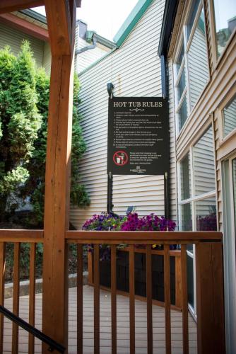 a sign on a porch of a house with flowers at Gibsons Garden Hotel in Gibsons
