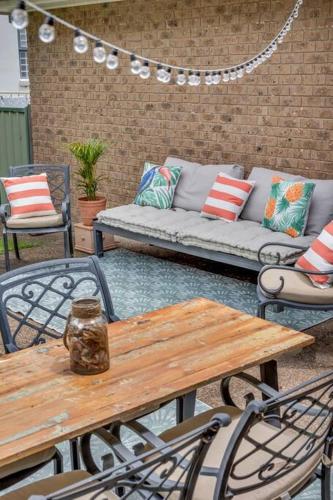 a patio with a couch and a table and chairs at Seaglass at Pambula Beach in Pambula Beach