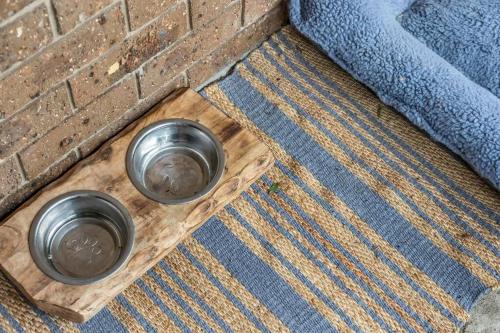 two metal bowls sitting on a wooden cutting board at Seaglass at Pambula Beach in Pambula Beach