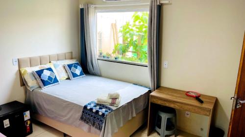 a small bedroom with a bed and a window at Pousada OPA - O Paraíso é Aqui Abrolhos in Caravellas