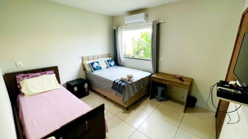a small bedroom with a bed and a window at Pousada OPA - O Paraíso é Aqui Abrolhos in Caravellas