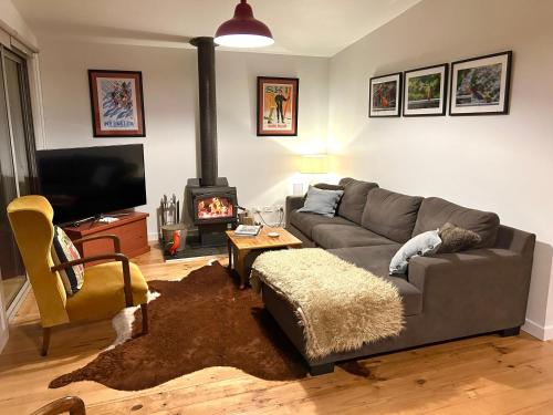 a living room with a couch and a fireplace at Wanyiora - Lake views and family friendly in Jamieson