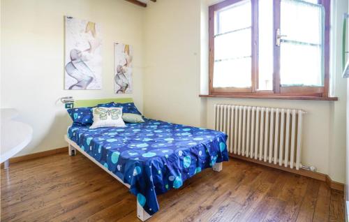 een slaapkamer met een bed met blauwe lakens en een raam bij Awesome Apartment In Castel San Gimignano With Wifi in Castel San Gimignano