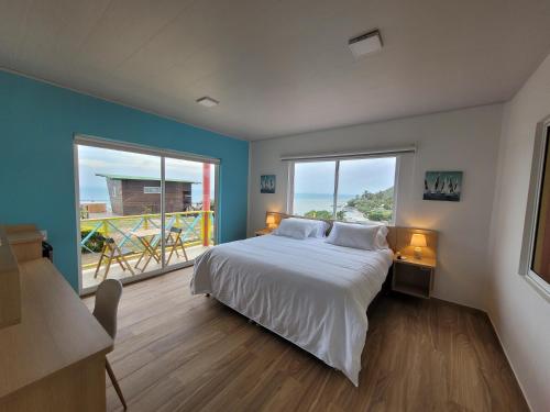 1 dormitorio con cama y ventana grande en 321 Surprise Beach house and Glamping en Providencia