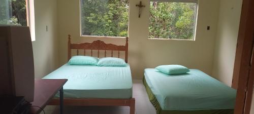 two twin beds in a room with two windows at Sítio Recanto das Pedras /Boca da Mata Ijaci in Ijaci