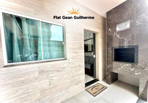 um quarto com uma televisão e uma parede com uma grande janela em Flat Gean Guilherme - Canasvieiras em Florianópolis