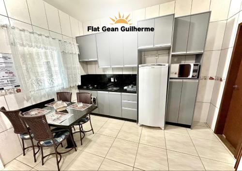 a kitchen with a table and chairs and a refrigerator at Flat Gean Guilherme - Canasvieiras in Florianópolis
