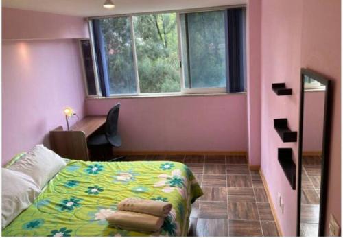 a bedroom with a bed and a pink wall at Depto equipado, a min del Centro Historico, Cdmx. in Mexico City