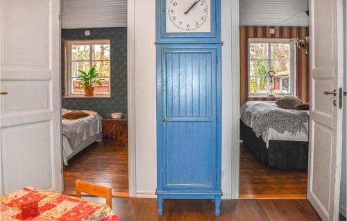une chambre avec une porte bleue et une horloge sur le mur dans l'établissement Lovely Home In Hllviken With Kitchen, à Höllviken