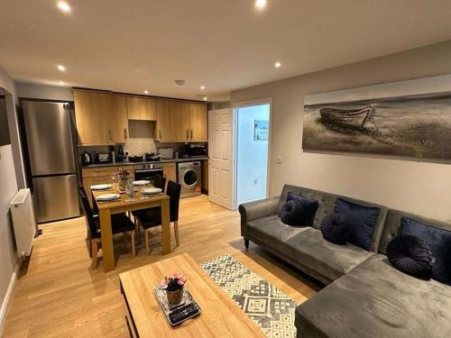 a living room with a couch and a table at Contemporary, Stylish Apartment in Weston in Worle