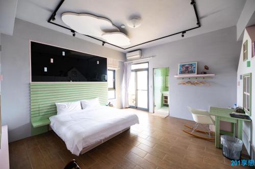 馬公市的住宿－撒野旅店，卧室配有白色的床和书桌