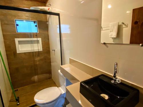 ein Bad mit einem Waschbecken, einem WC und einer Dusche in der Unterkunft pousada do caneca in Senador Amaral