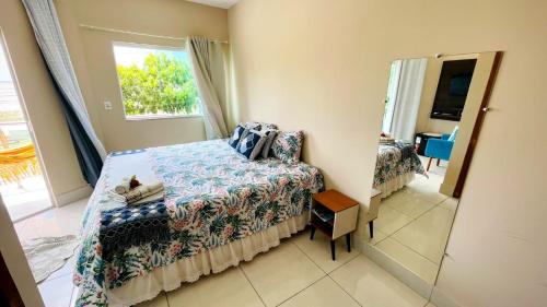 a bedroom with a bed and a window at Pousada OPA - O Paraíso é Aqui Abrolhos in Caravellas