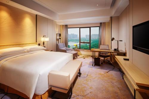 a hotel room with a bed and a desk and a computer at Hilton Suzhou in Suzhou