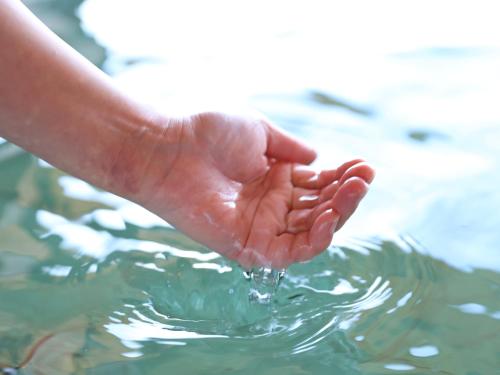 a person holding their hand in the water at Hotel Asafuji in Fujikawaguchiko
