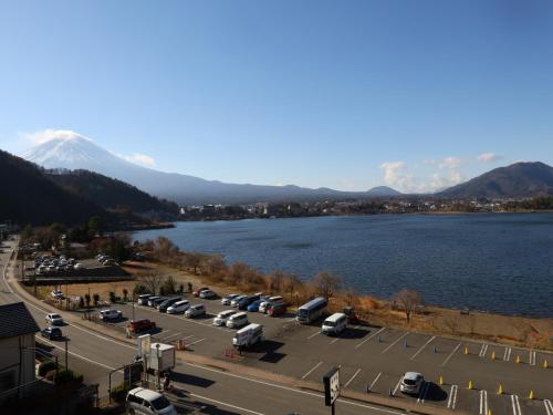 a parking lot with cars parked next to a body of water at Hotel Asafuji in Fujikawaguchiko