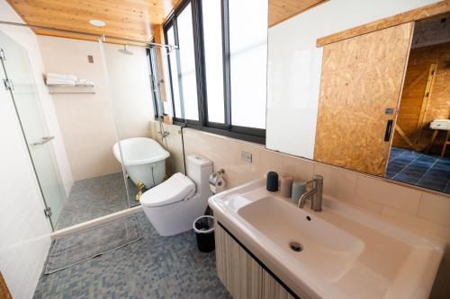 馬公市的住宿－撒野旅店，一间带水槽、卫生间和镜子的浴室