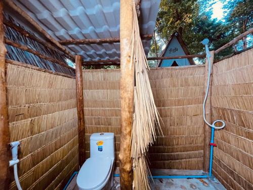 e bagno con servizi igienici su una parete in legno. di Blue Shore Pavilion a Phumĭ Kâoh Rŏng
