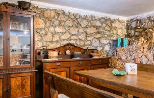 a kitchen with a table and a stone wall at Villa Country Lady in Kršan