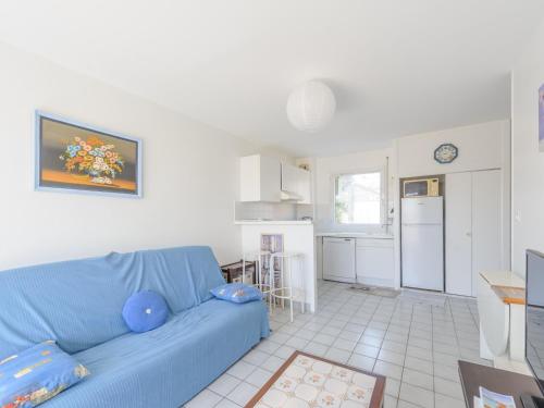 un salon avec un canapé bleu et une cuisine dans l'établissement Appartement T2 à 50m de la Plage, Balcon, Wifi, Tout Confort, 4 Pers, Châtelaillon-Plage - FR-1-535-9, à Châtelaillon-Plage