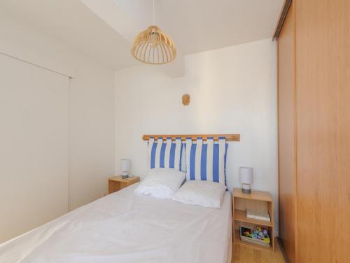 une chambre avec un lit à rayures bleues et blanches dans l'établissement Appartement T2 à 50m de la Plage, Balcon, Wifi, Tout Confort, 4 Pers, Châtelaillon-Plage - FR-1-535-9, à Châtelaillon-Plage